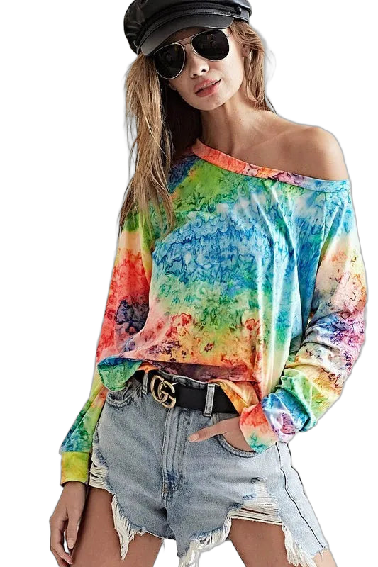 Model in off-shoulder rainbow tie-dye long-sleeve tee paired with distressed light denim shorts and black cap