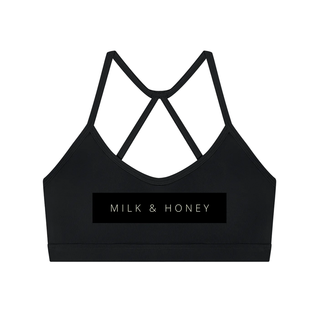 Black sports bra with thin crisscross back straps and centered 'MILK & HONEY' rectangular logo