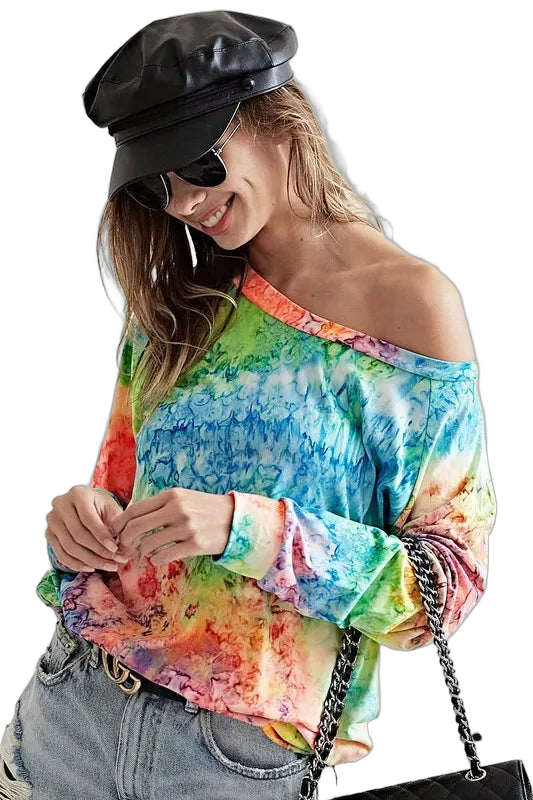 Woman wearing off-shoulder multicolor tie-dye long-sleeve knit top with denim jeans, black leather cap, sunglasses, and…